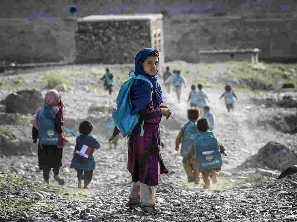 Afghan children run to school on Sept. 24. Whoever takes over as the next U.S. president will have to determine how many troops will remain after the December 2014 deadline to help with long-term security.