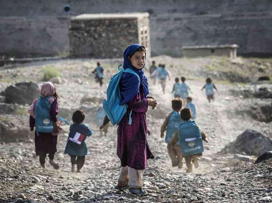 Afghan children run to school on Sept. 24. Whoever takes over as the next U.S. president will have to determine how many troops will remain after the December 2014 deadline to help with long-term security.