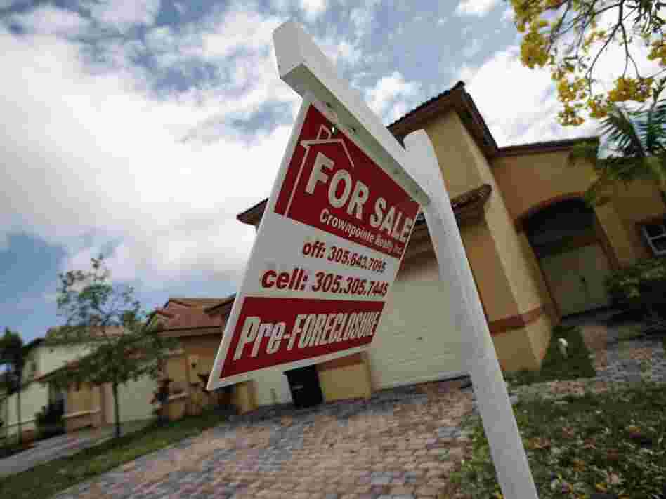 A for-sale sign hangs in front of a Homestead, Fla., home. In terms of the housing market, the presidential candidates differ most on regulation.