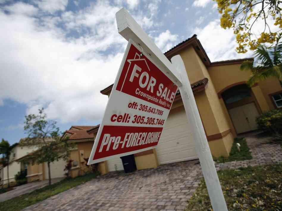 A for-sale sign hangs in front of a Homestead, Fla., home. In terms of the housing market, the presidential candidates differ most on regulation.