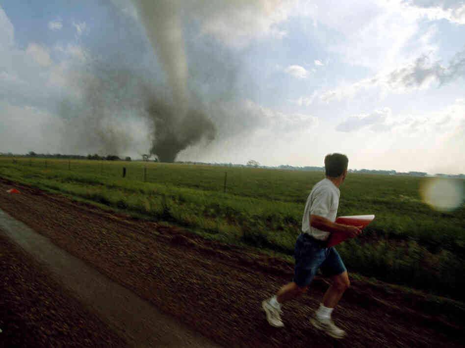 A storm chaser (a kind of weather scientist) places a probe in the path of a tornado in South Dakota. A storm chaser (a kind of weather scientist) places a probe in the path of a tornado in South Dakota.