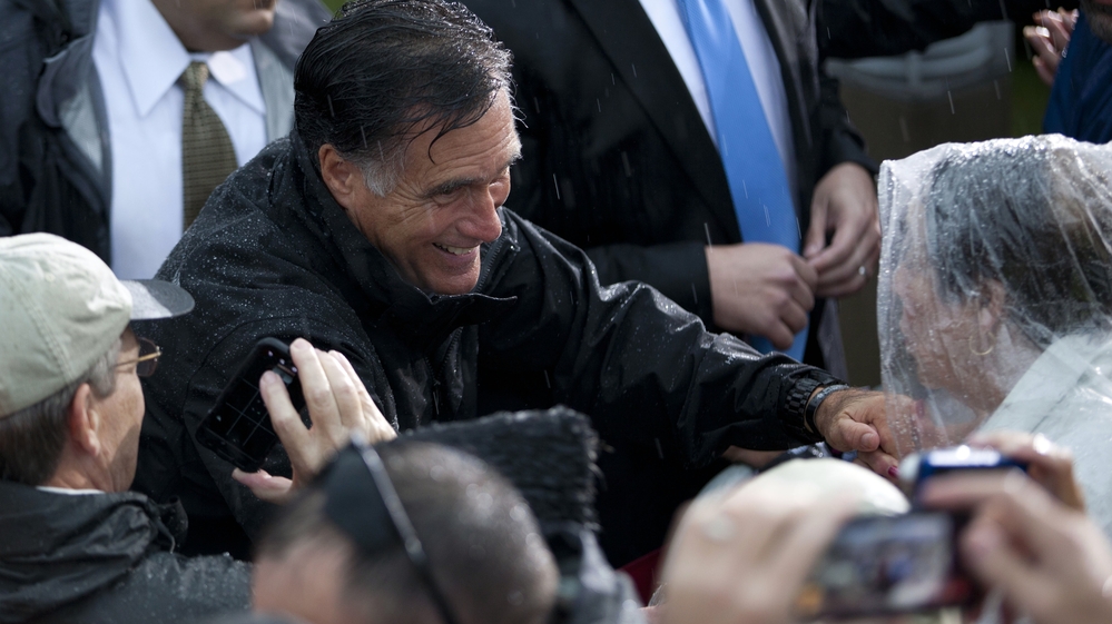 Republican presidential candidate Mitt Romney shakes hands during a rainy campaign rally Monday in Newport News, Va.