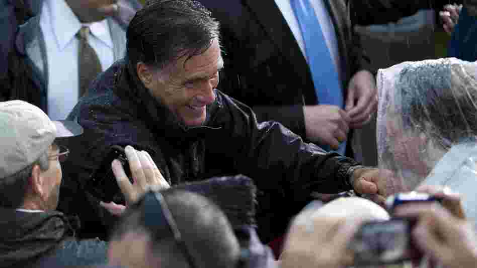 Republican presidential candidate Mitt Romney shakes hands during a rainy campaign rally Monday in Newport News, Va.