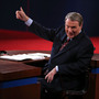 Moderator Jim Lehrer gestures before the presidential debate at the University of Denver last week. Moderators must finagle answers out of sometimes-dodgy politicians and keep control, all without seeming to get in the way.