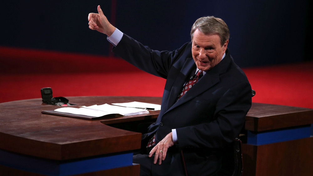 Moderator Jim Lehrer gestures before the presidential debate at the University of Denver last week. Moderators must finagle answers out of sometimes-dodgy politicians and keep control, all without seeming to get in the way.