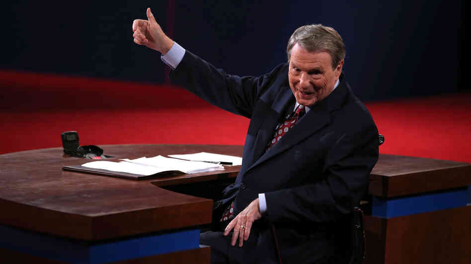 Moderator Jim Lehrer gestures before the presidential debate at the University of Denver last week. Moderators must finagle answers out of sometimes-dodgy politicians and keep control, all without seeming to get in the way.