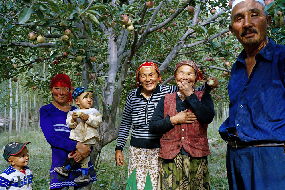Torukun, the eldest daughter of the Kuruman family (third from right), with her father, mother-in-law, sister-in-law and nephews, poses for a photograph outside her house. Torukun raises cattle and lives in a village away from her parents.