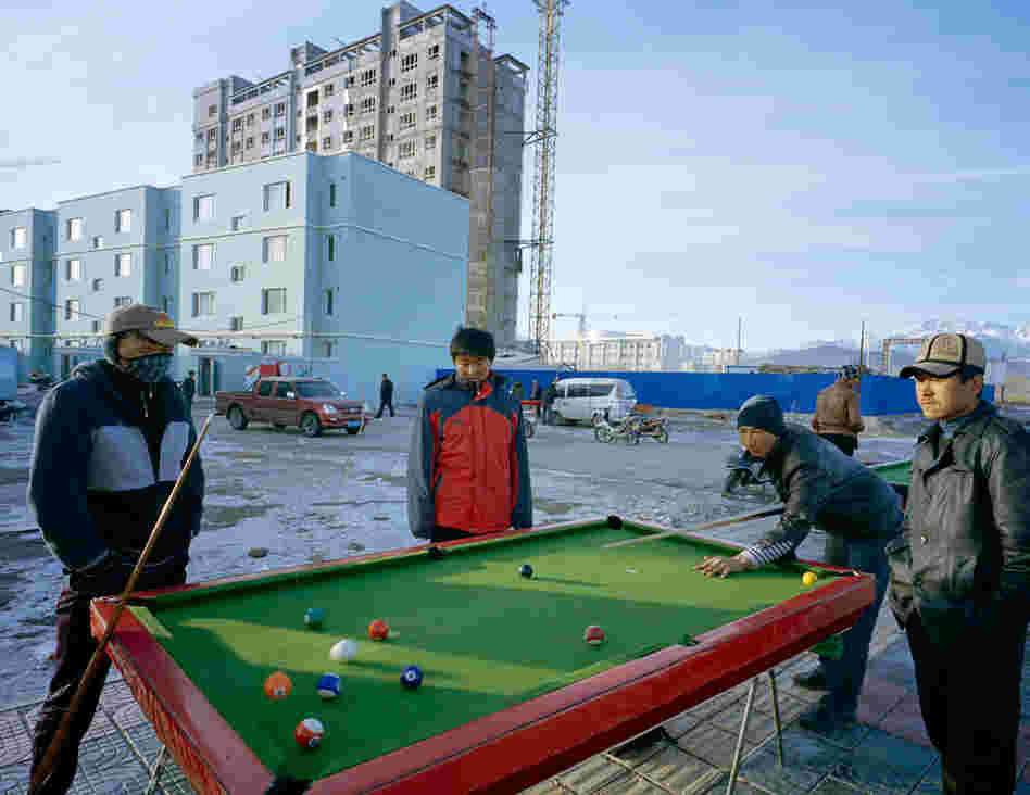 New residents of an apartment building in Wuqiaxian play pool outside. Some youth see a new highway as an opportunity, Takayama says. It will generate inward and outward fluidity of people, goods and culture.