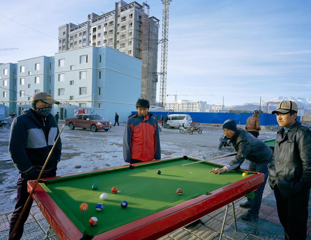 New residents of an apartment building in Wuqiaxian play pool outside. Some youth see a new highway as an opportunity, Takayama says. It will generate inward and outward fluidity of people, goods and culture.