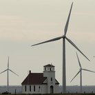 Wind turbines dwarf a church near Wilson, Kan. The White House wants to extend a federal wind energy credit, but the Romney campaign wants to let it expire.