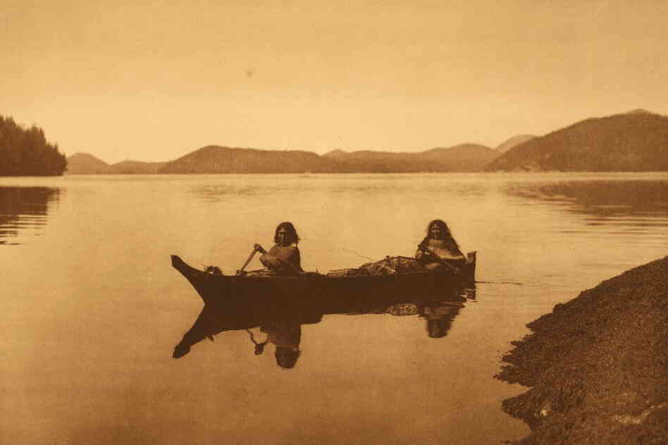 "Two Hesquiat women," reads the Curtis caption, "are homeward bound with the product of their day's labor in gathering food, and cedar-bark to be used in making mats."