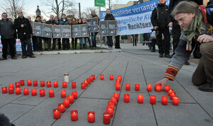A man lights candles during a Nov. 28 commemoration vigil in the eastern German town of Erfurt for the victims of murders allegedly committed by a right-wing extremist group with ties to the NPD.