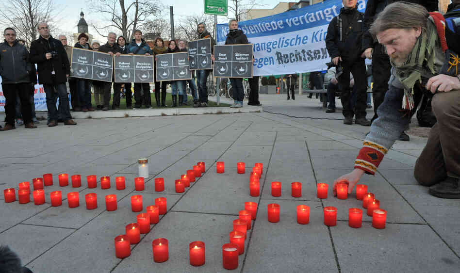 A man lights candles during a Nov. 28 commemoration vigil in the eastern German town of Erfurt for the victims of murders allegedly committed by a right-wing extremist group with ties to the NPD. A man lights candles during a Nov. 28 commemoration vigil in the eastern German town of Erfurt for the victims of murders allegedly committed by a right-wing extremist group with ties to the NPD.