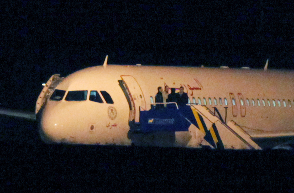 People speak atop the aircraft steps of a Syrian passenger plane that was forced by Turkish jets to land at Esenboga airport in Ankara, Turkey, early Thursday.
