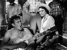 Andy Griffith playing guitar as Patricia Neal watches in a scene from the Elia Kazan's A Face In The Crowd. Andy Griffith playing guitar as Patricia Neal watches in a scene from the Elia Kazan's A Face In The Crowd.