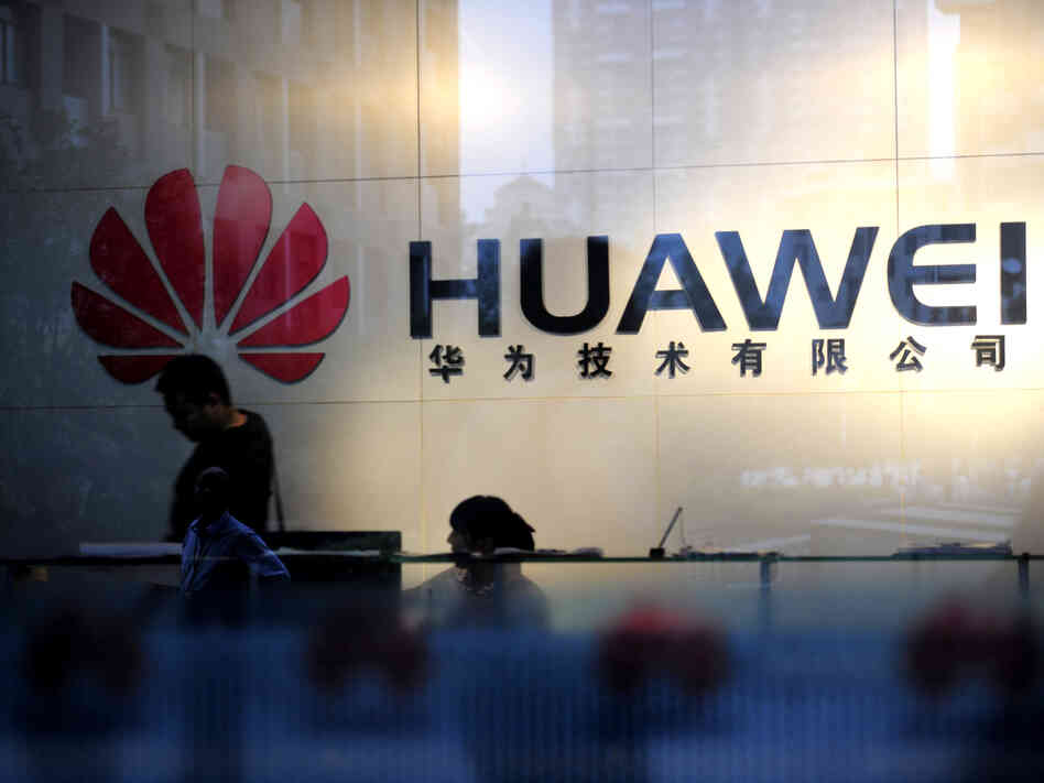 Staff and visitors walk past the lobby at the Huawei office in Wuhan, China. Beijing has urged Washington to "set aside prejudices" after a draft congressional report said Chinese telecom firms Huawei and ZTE were security threats that should be banned from business in the U.S.