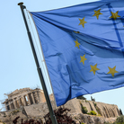 European Union flag and Greek flag wave in front of the Acropolis, in central Athens.