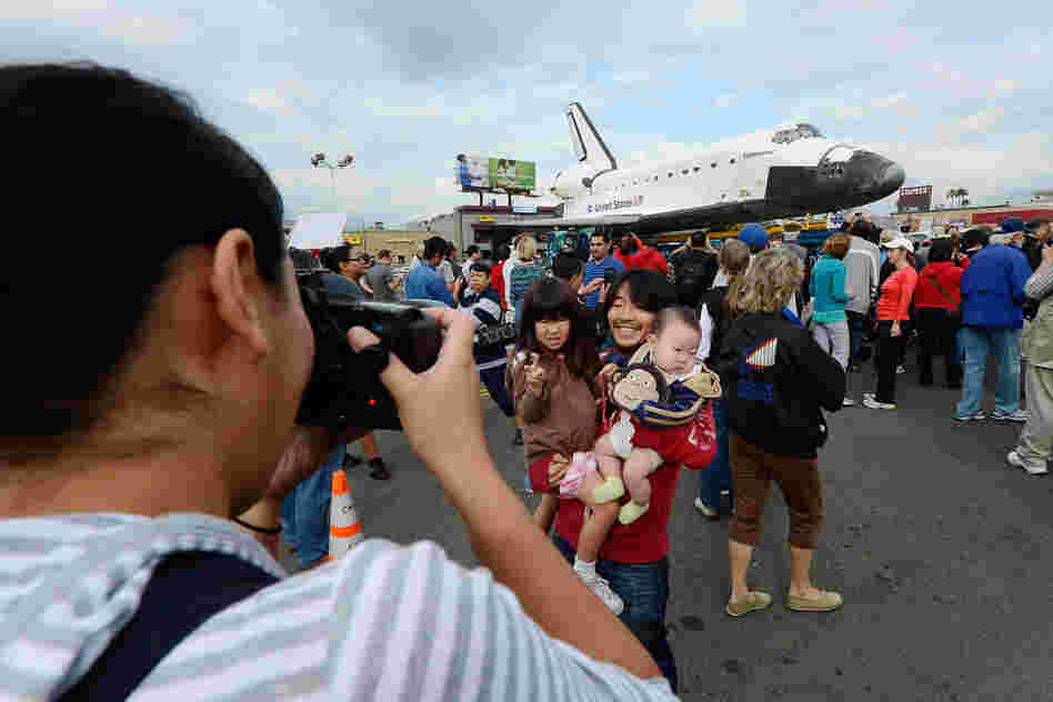 Mifumi Nakajima takes a picture of her husband Nozomo Nakajima holding their children Leigha Nakajima, 3, and Eli Nakajima, 6 months, in front of the space shuttle Endeavour parked in a mall parking lot. Mifumi Nakajima takes a picture of her husband Nozomo Nakajima holding their children Leigha Nakajima, 3, and Eli Nakajima, 6 months, in front of the space shuttle Endeavour parked in a mall parking lot.