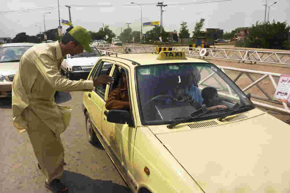 Khan Wali, 21, scrutinizes passing cars for young children at the traffic checkpoint. If a child appears to be younger than 5, the driver must pull over.