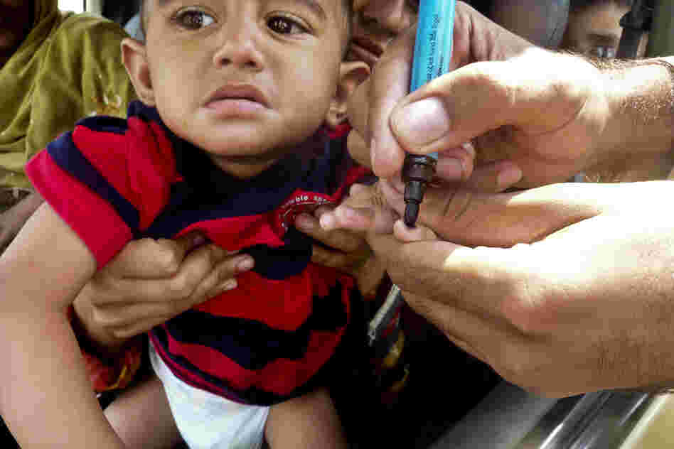 Wali marks a child's finger with ink after administering the polio vaccine. Children need to be inoculated multiple times in order to be fully immunized against the virus.