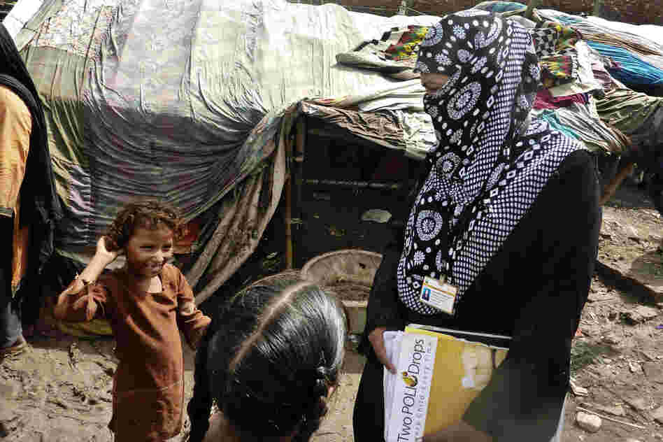 Social mobilizers like Awaiz Amjad (right) walk through dense slums and go door to door inoculating children. Many children are malnourished, with weak immune systems.