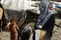 Social mobilizers like Awaiz Amjad (right) walk through dense slums and go door to door inoculating children. Many children are malnourished, with weak immune systems.