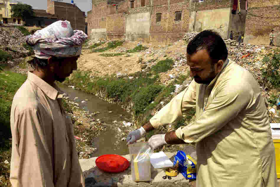 Health care workers take samples of sewage water to check for the polio virus in Rawalpindi, a city near Islamabad known to be at high-risk for polio.