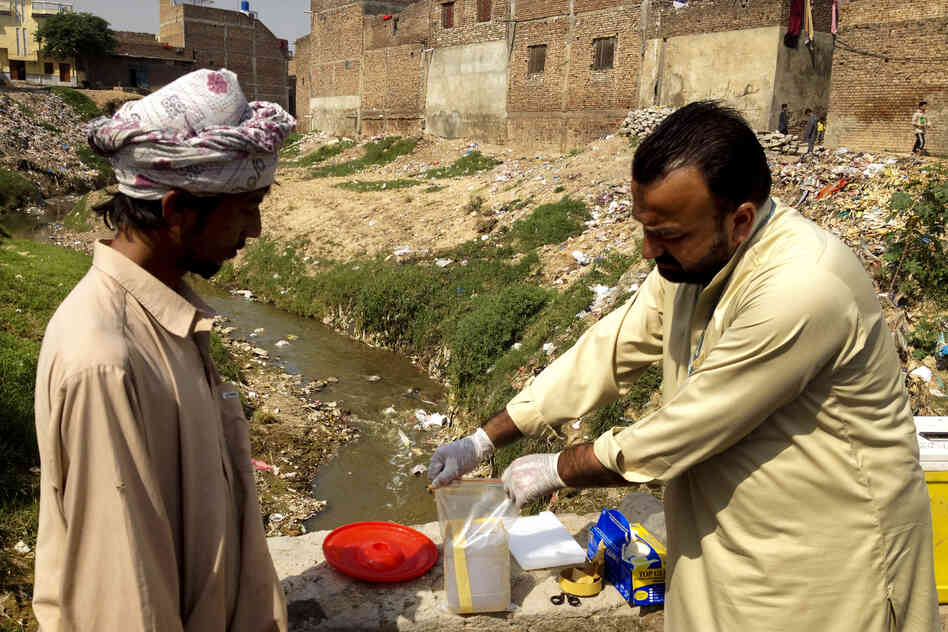 Health care workers take samples of sewage water to check for the polio virus in Rawalpindi, a city near Islamabad known to be at high-risk for polio.