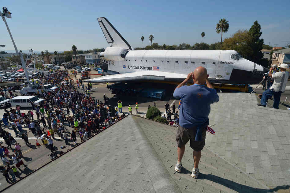 At every turn of Endeavour's stop-and-go commute through urban streets, a constellation of spectators trailed along as the space shuttle ploddingly nosed past stores, schools, churches and front yards.