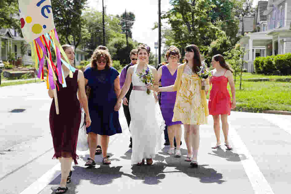 Dyer holds hands with her mother during her wedding parade in June. Despite a rocky childhood that left scars, Dyer has repaired her relationship with her mom, earned a PhD in yeast genetics, and gained confidence through participation in women's arm wrestling.