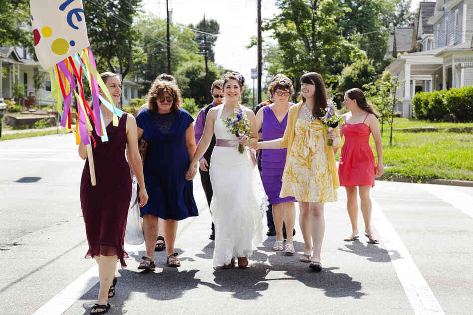 Dyer holds hands with her mother during her wedding parade in June. Despite a rocky childhood that left scars, Dyer has repaired her relationship with her mom, earned a PhD in yeast genetics, and gained confidence through participation in women's arm wrestling.
