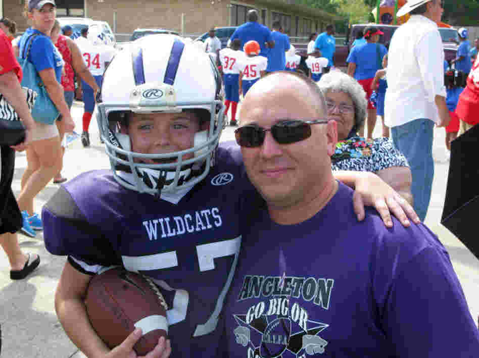 Bryce Rolan, 8, and his dad, Wesley, at a Wildcat game in Angleton, Texas. At 4 feet 2 inches and 65 pounds, Bryce is playing his first year of tackle football.