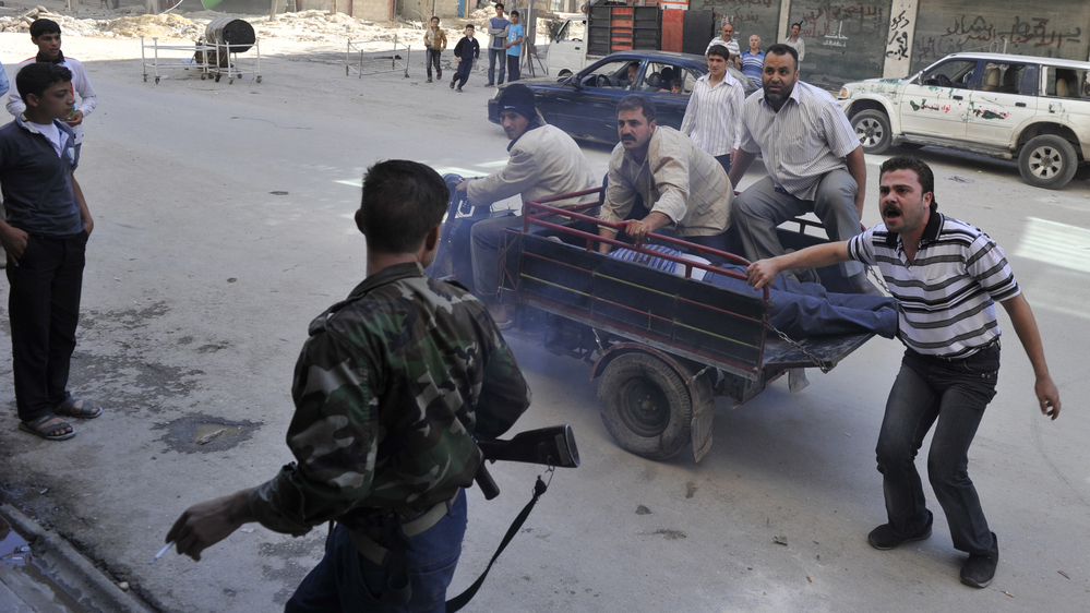 Syrians deliver an injured civilian to a hospital in the northern city of Aleppo on Saturday, following shelling by government forces.