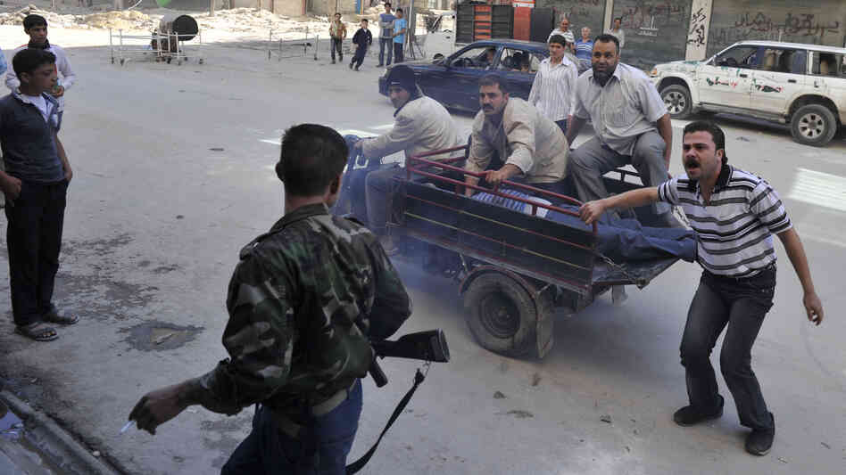 Syrians deliver an injured civilian to a hospital in the northern city of Aleppo on Saturday, following shelling by government forces.
