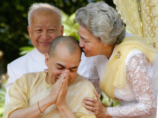 Sihanouk looks on as his wife, Queen Monineath, kisses his son and successor, King Norodom Sihamoni, at a coronation ceremony at the Royal Palace in Phnom Penh on Oct. 29, 2004.