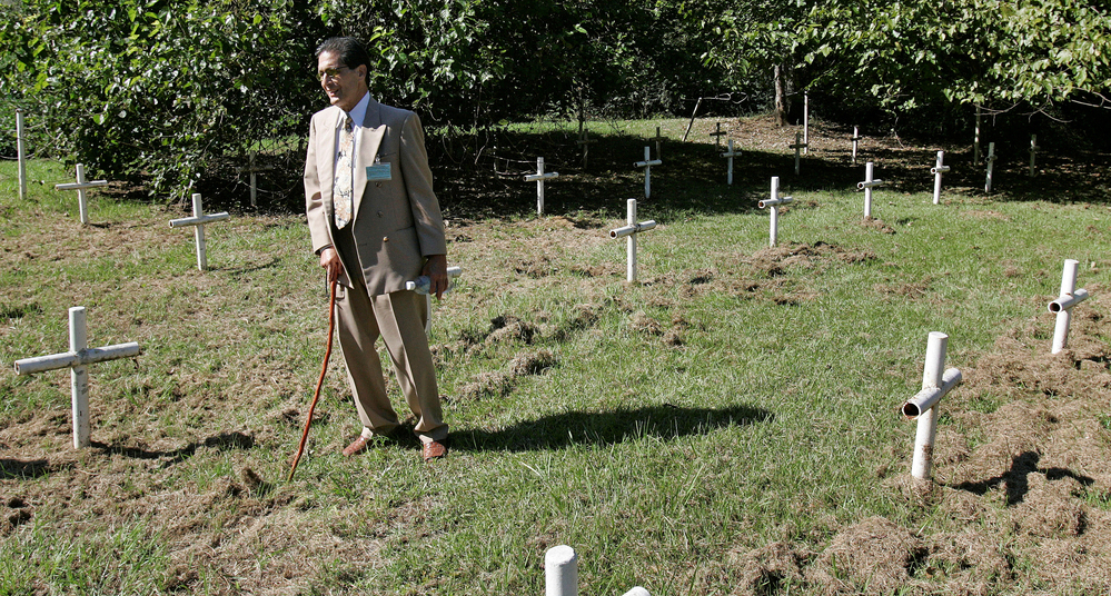 Dick Colon, one of the White House Boys, walks through grave sites near the Dozier School for Boys in Marianna, Fla. Several men who suffered abuse and severe beatings believe the crosses mark the graves of boys who were killed at the school, victims of punishments that went too far.