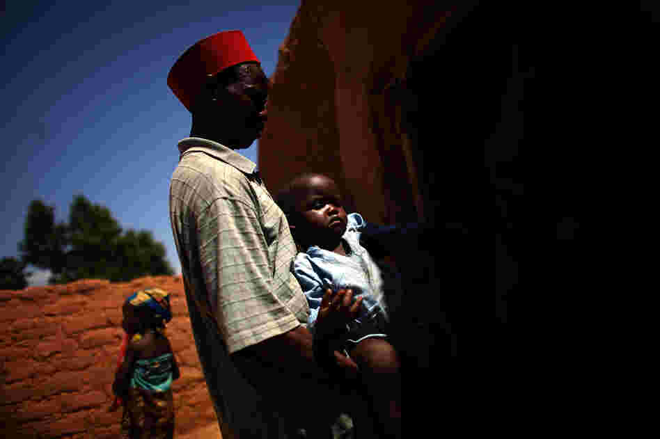 Ado Ibrahim carries his son Aminu through the village of Minjibir in northern Nigeria. Aminu, 4, was paralyzed by polio in August.