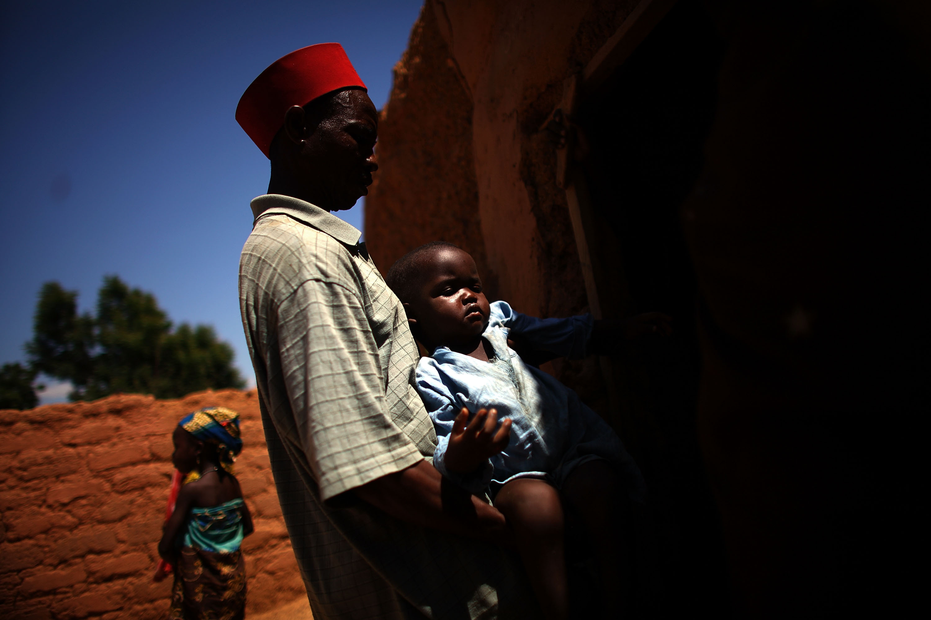 Ado Ibrahim carries his son Aminu through the village of Minjibir in northern Nigeria. Aminu, 4, was paralyzed by polio in August.