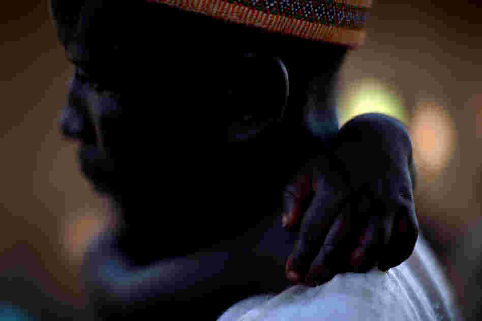 Adamu Ali carries his 4-year-old son, Omar, who was stricken with polio earlier this year. They live in the village of Minjibir.