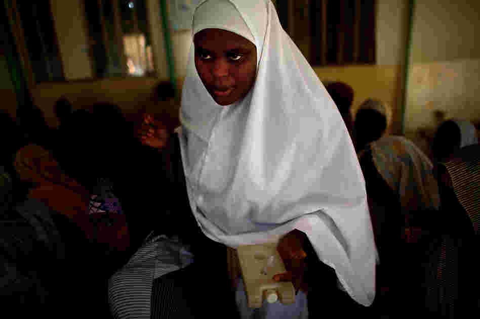 Sahya Idriss, a service provider at the health clinic in Minjibir, carries a vial of the polio vaccine.