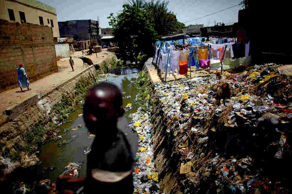 A child crosses a bridge over the cement-lined Gogo stream, which flows behind the main market in Kano. Sanitation workers regularly test the sewage here for the presence of the polio virus.