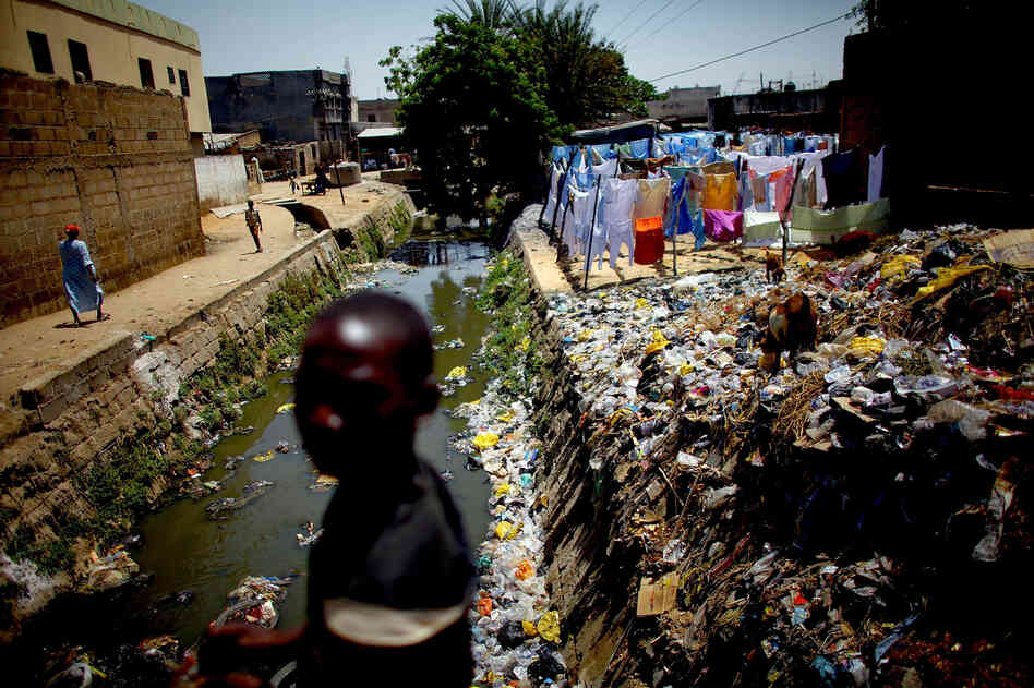 A child crosses a bridge over the cement-lined Gogo stream, which flows behind the main market in Kano. Sanitation workers regularly test the sewage here for the presence of the polio virus.