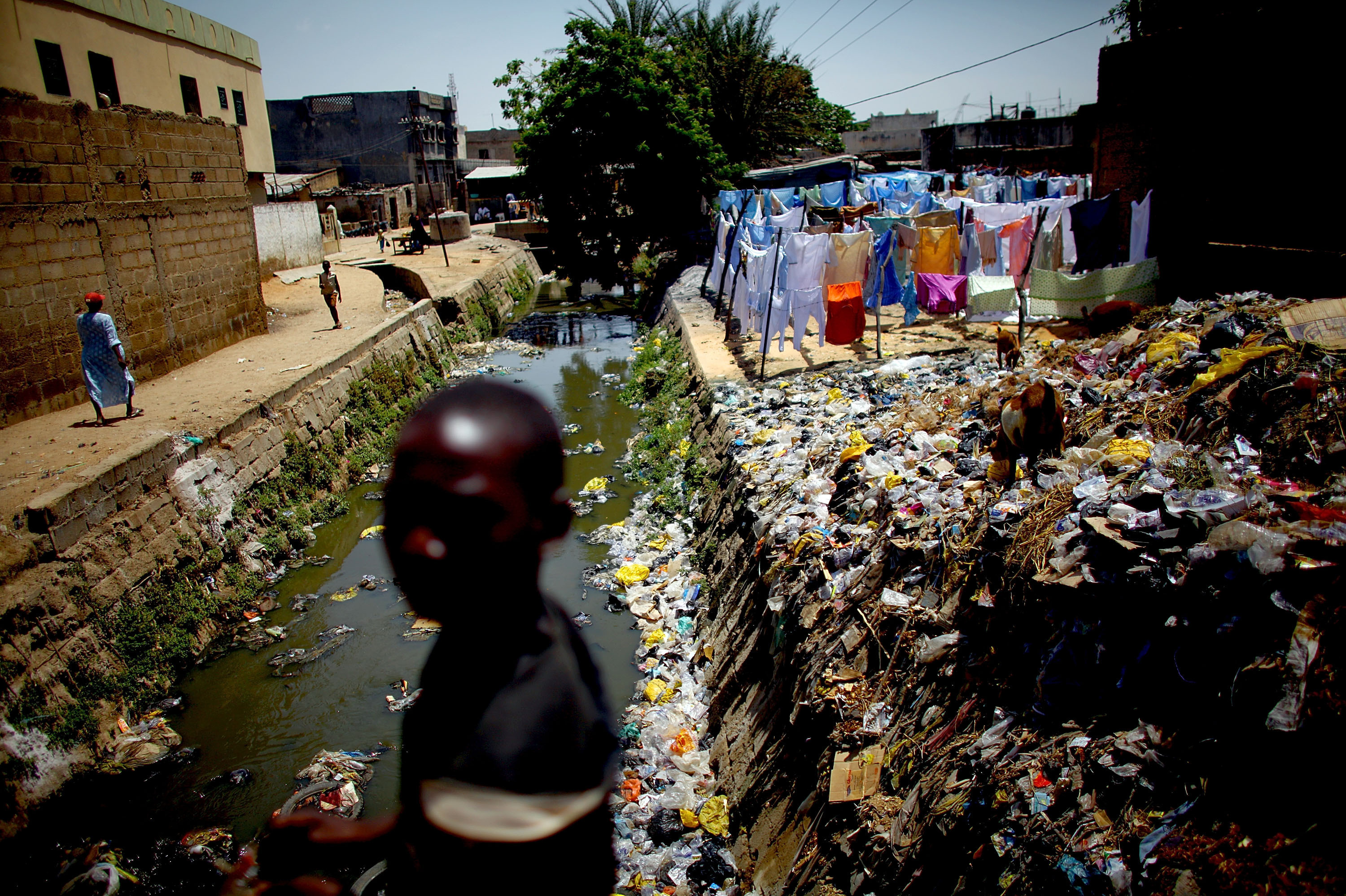 A child crosses a bridge over the cement-lined Gogo stream, which flows behind the main market in Kano. Sanitation workers regularly test the sewage here for the presence of the polio virus.