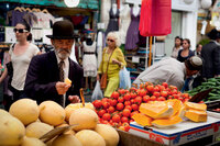 A shopper chooses a melon from a market stall in Jerusalem.