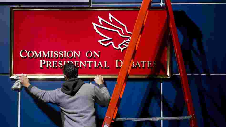 A worker cleans a sign before Tuesday's presidential debate at Hofstra University in Hempstead, N.Y.