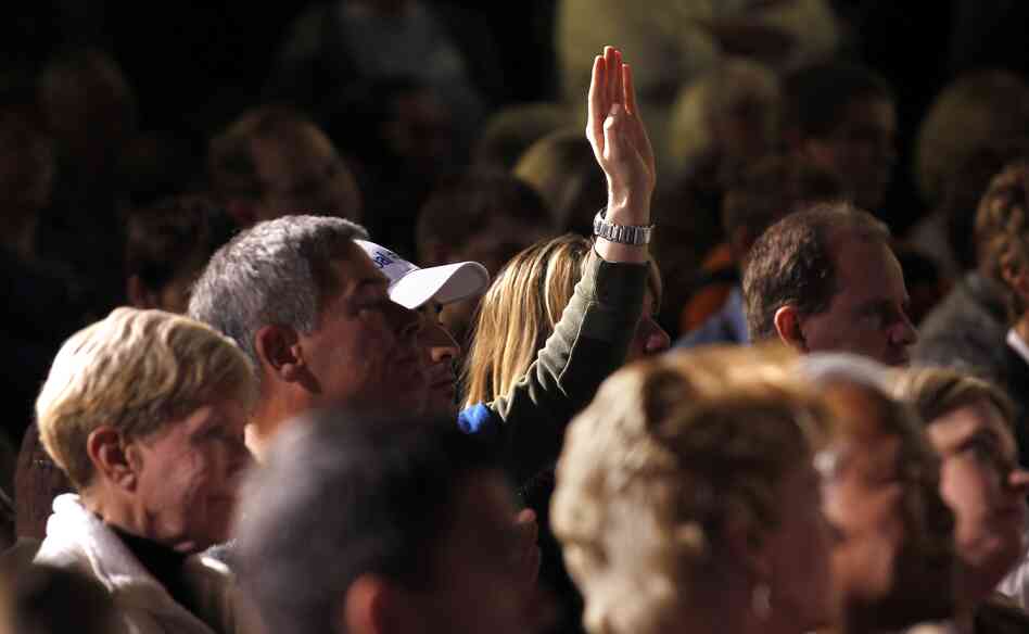 An audience member holds up his hand at a Mitt Romney town hall meeting in Dayton, Ohio, in March. Audience members will be allowed to ask questions at the second presidential debate, being held Tuesday night in Hempstead, N.Y.