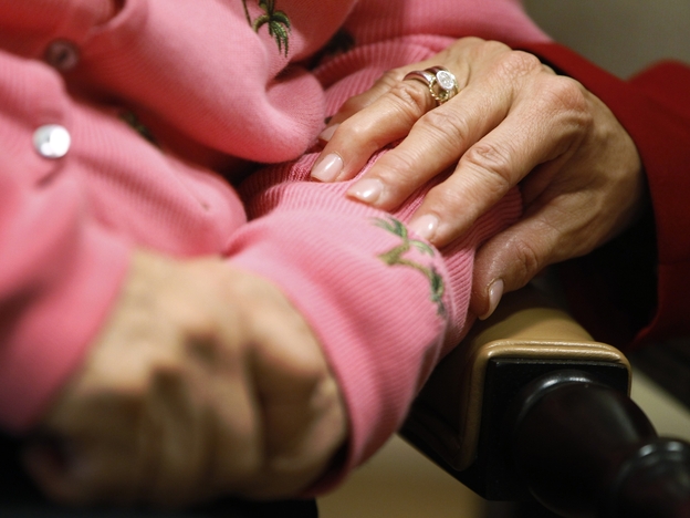 Alexis McKenzie, executive director of the Methodist Home of the District of Columbia Forest Side, an Alzheimer's assisted-living facility, puts her hand on the arm of resident Catherine Peake.