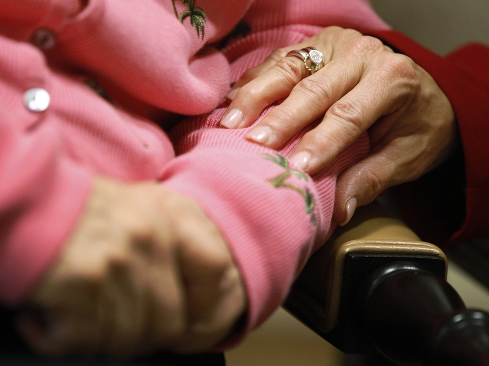 Alexis McKenzie, executive director of the Methodist Home of the District of Columbia Forest Side, an Alzheimer's assisted-living facility, puts her hand on the arm of resident Catherine Peake.