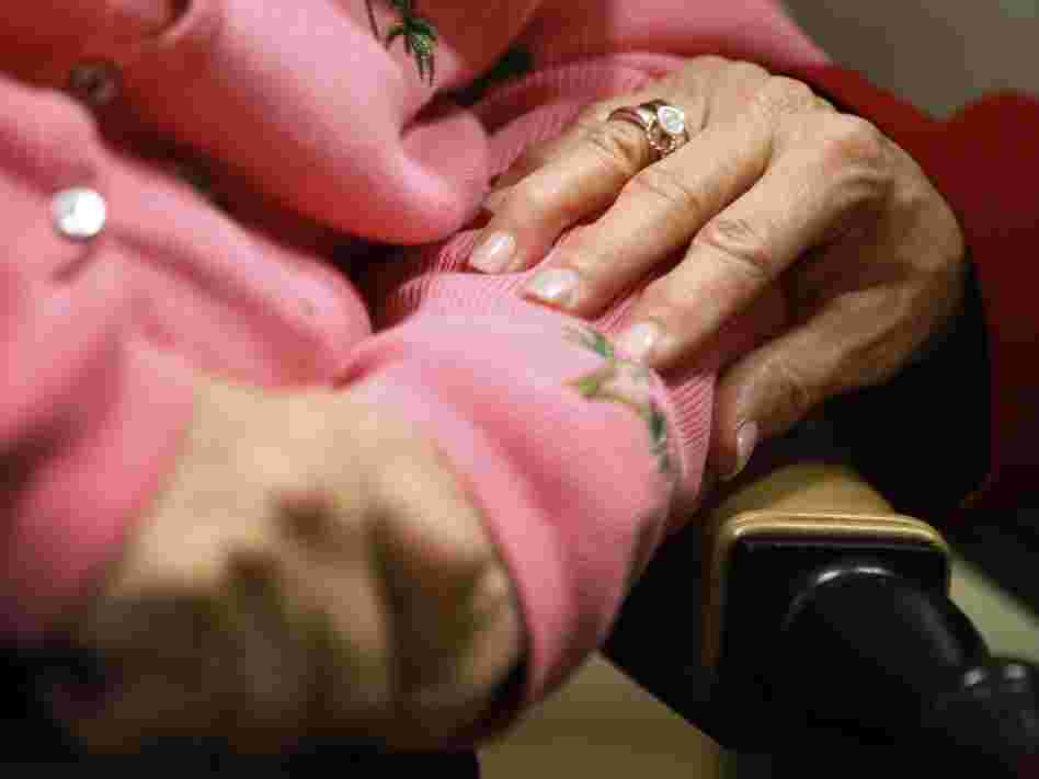 Alexis McKenzie, executive director of the Methodist Home of the District of Columbia Forest Side, an Alzheimer's assisted-living facility, puts her hand on the arm of resident Catherine Peake.