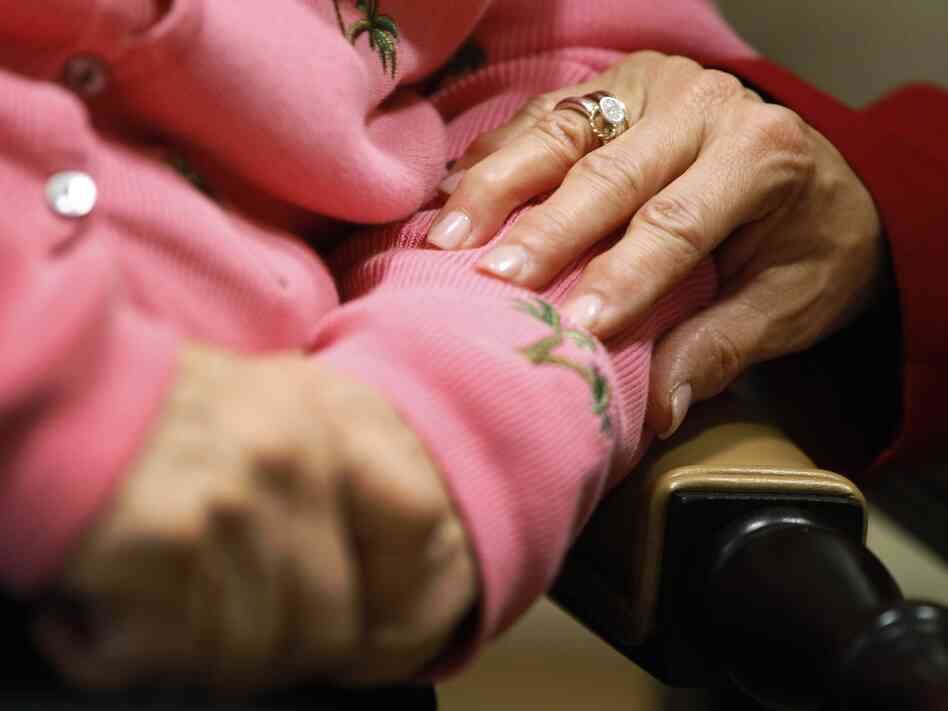 Alexis McKenzie, executive director of the Methodist Home of the District of Columbia Forest Side, an Alzheimer's assisted-living facility, puts her hand on the arm of resident Catherine Peake.